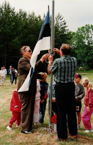Lapsed, vanim elanik Anne Robert ja külavanem Reinu Adi lippu heiskamas.JPG
